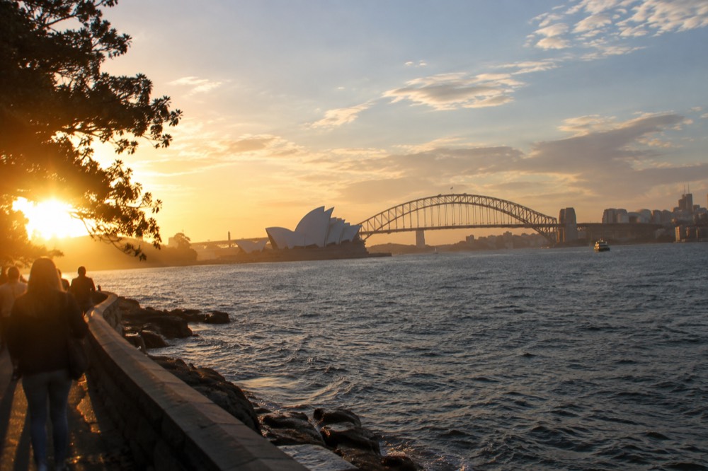 The bridge and Opera House photographed together from a harbourside point at golden hour