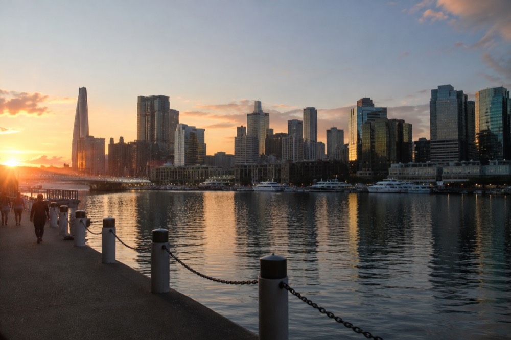 Darling Harbour waterfront at dusk with the city skyline reflected in the water