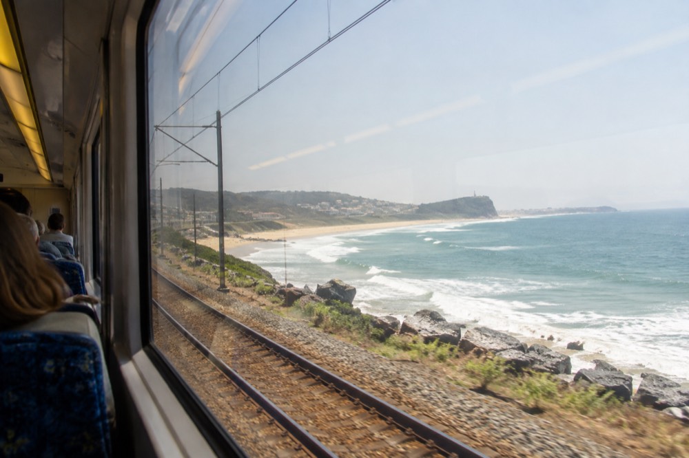 Intercity train travelling along a coastal rail line with the ocean in view