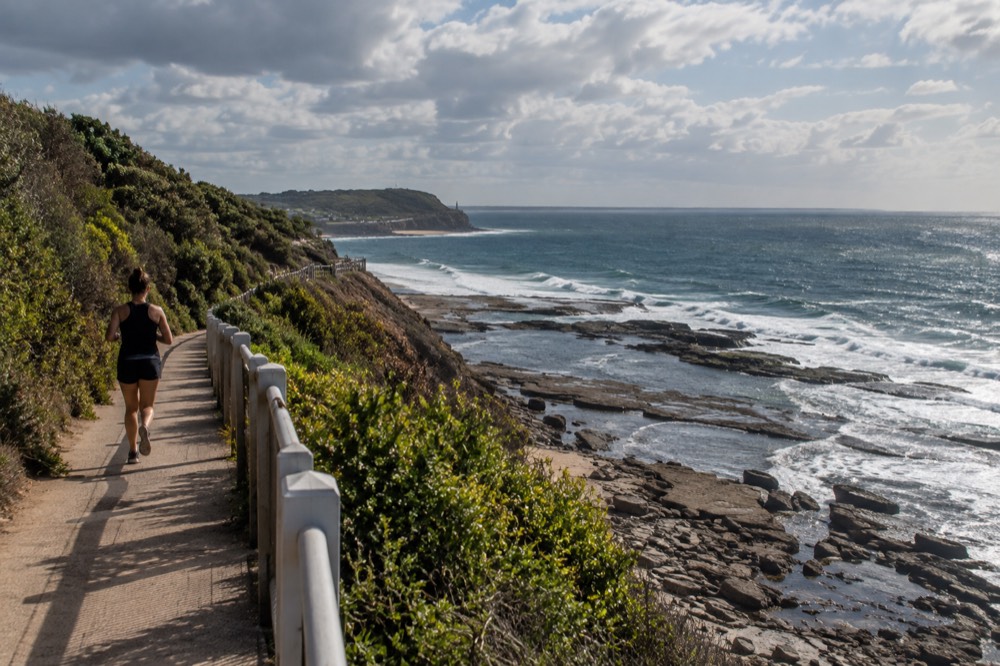 Clifftop coastal walking path with rock pools below and ocean horizon