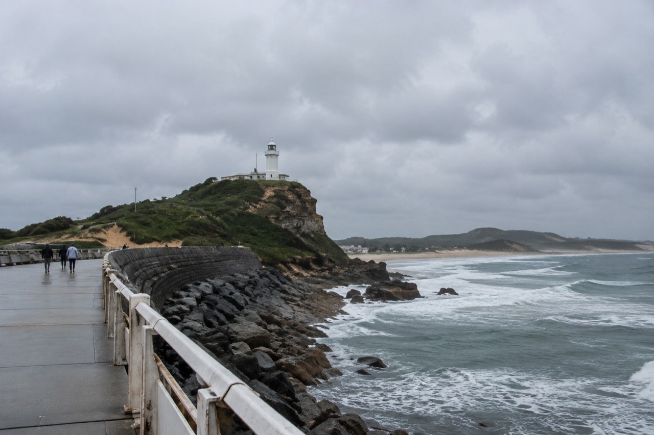 Newcastle harbour foreshore with a lighthouse on the headland and ocean beyond