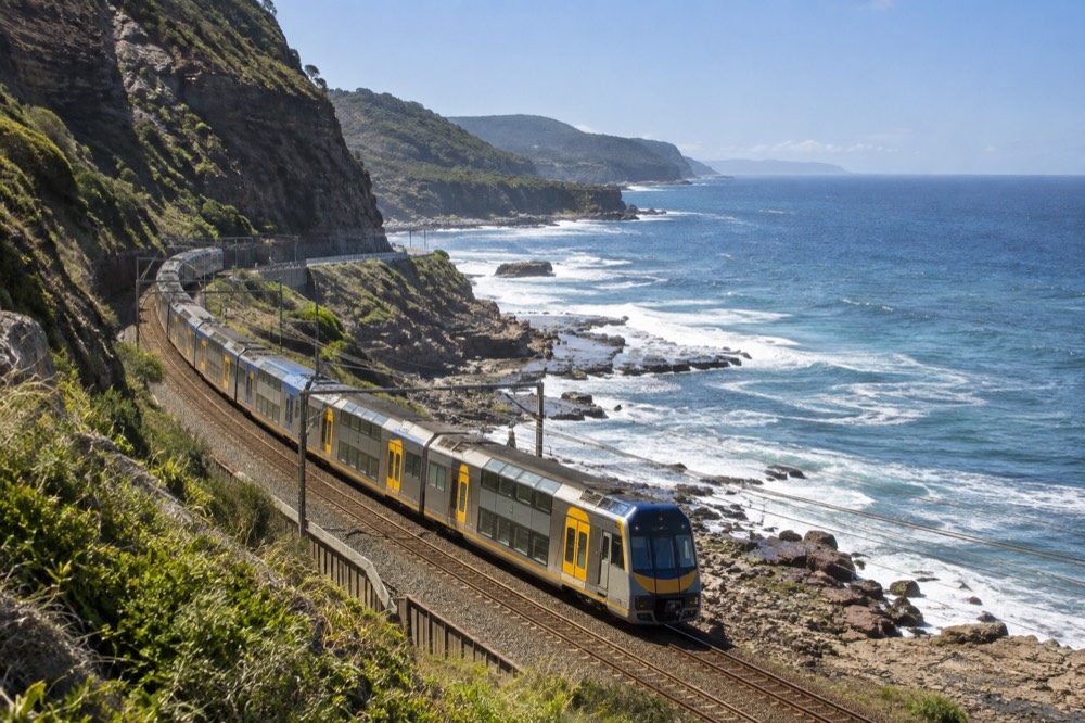 A train travelling along a coastal rail line beside the ocean