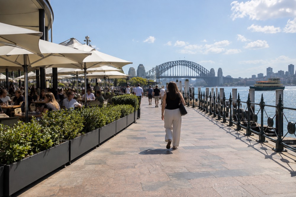 A level restaurant terrace along a harbour boardwalk with tables and umbrellas
