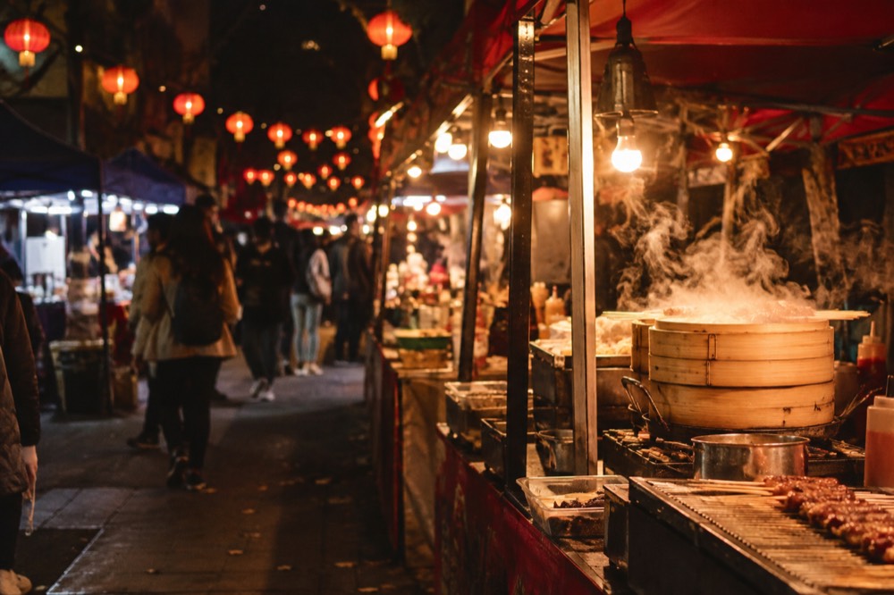 A busy night market street food stall glowing under lanterns in Chinatown Sydney