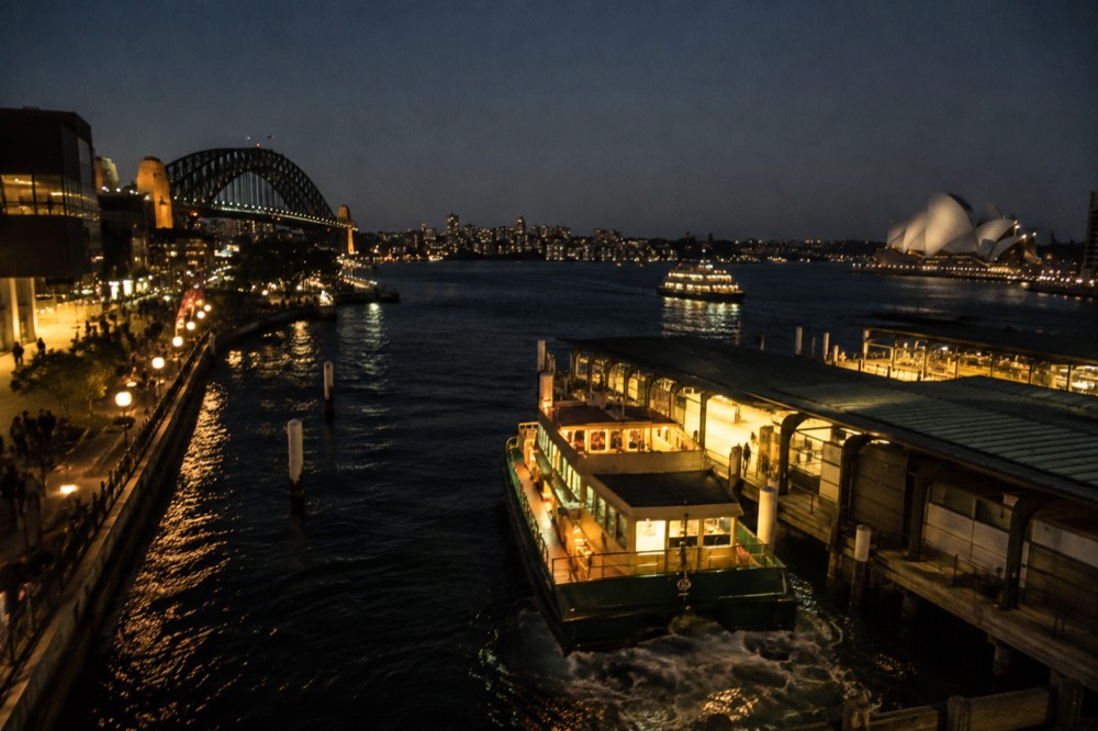 City skyline and harbour lit up at night seen from a northern foreshore vantage point