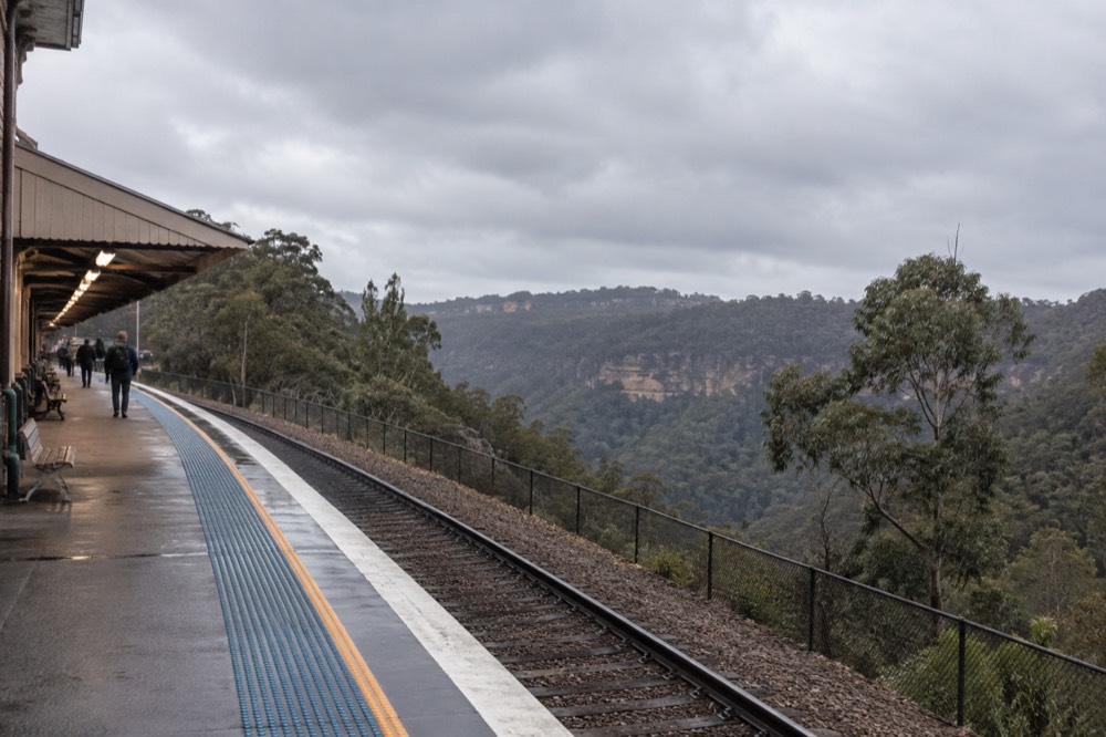 A train platform in the Blue Mountains with forested escarpment behind