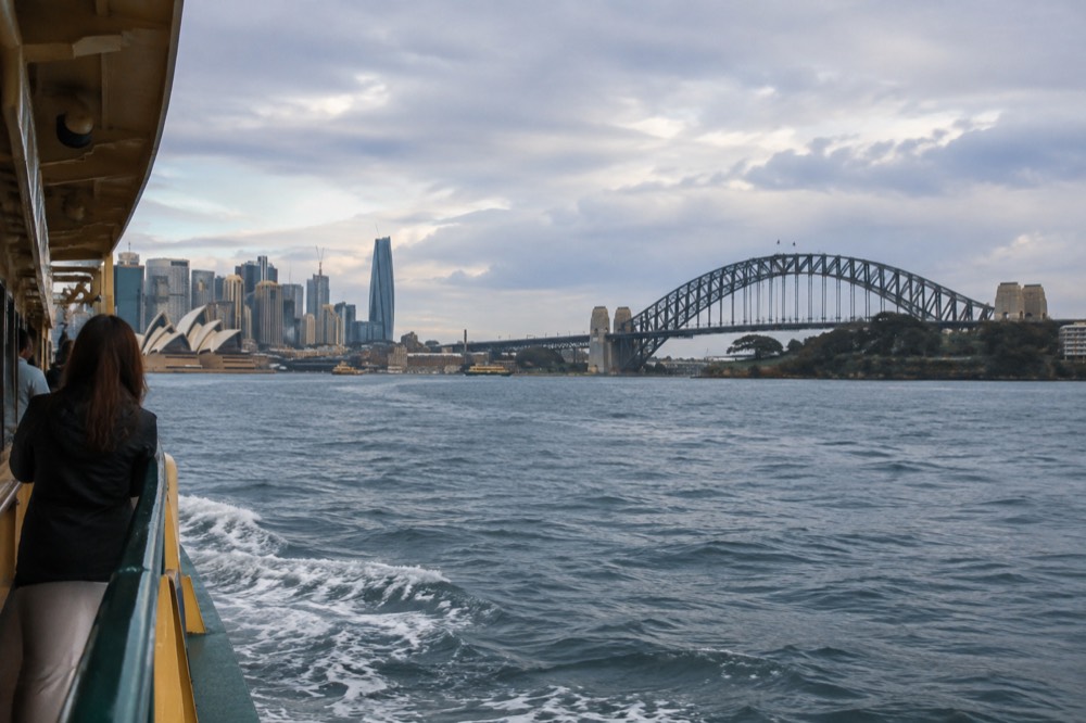 Sydney Harbour Bridge and city skyline seen from a ferry on the water