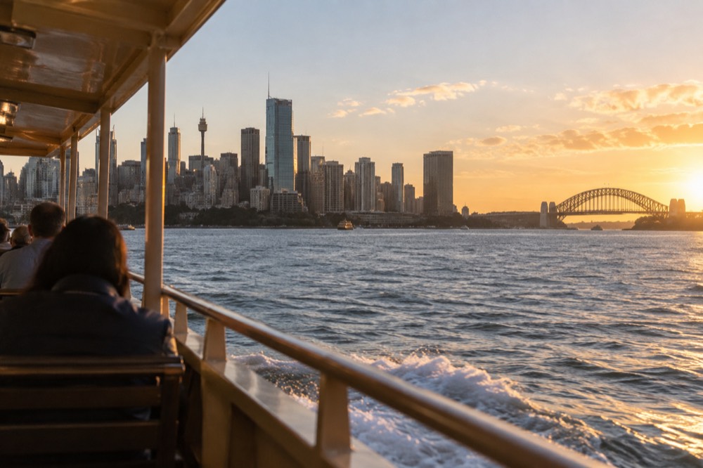 Ferry crossing Sydney Harbour with the city skyline behind it