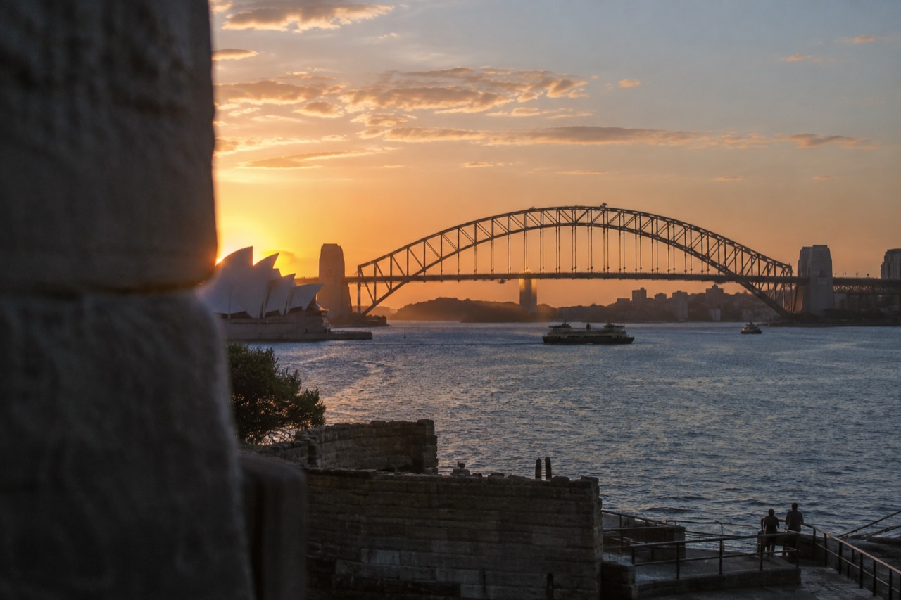 Sydney Harbour at dusk with the Opera House and Harbour Bridge along the water