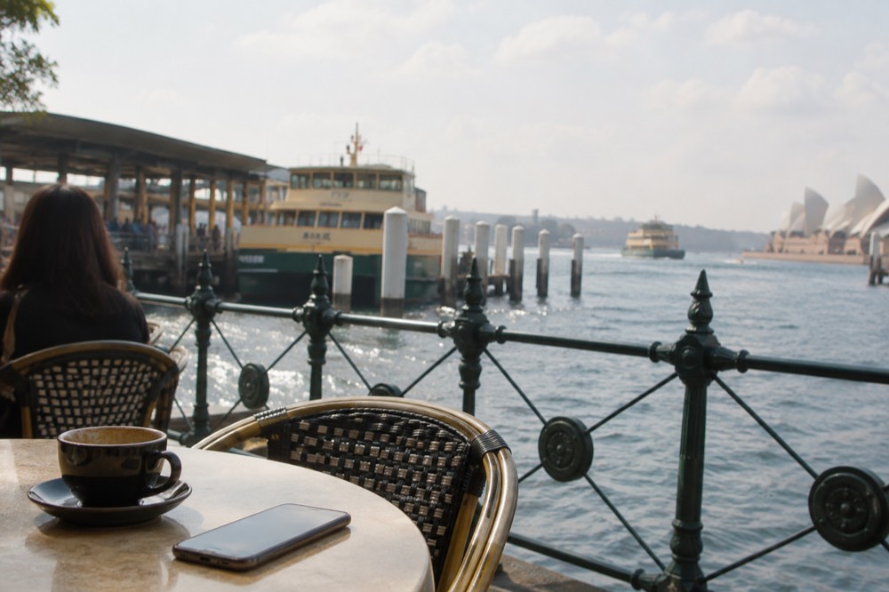 A cafe table with a phone showing a map of inner Sydney streets