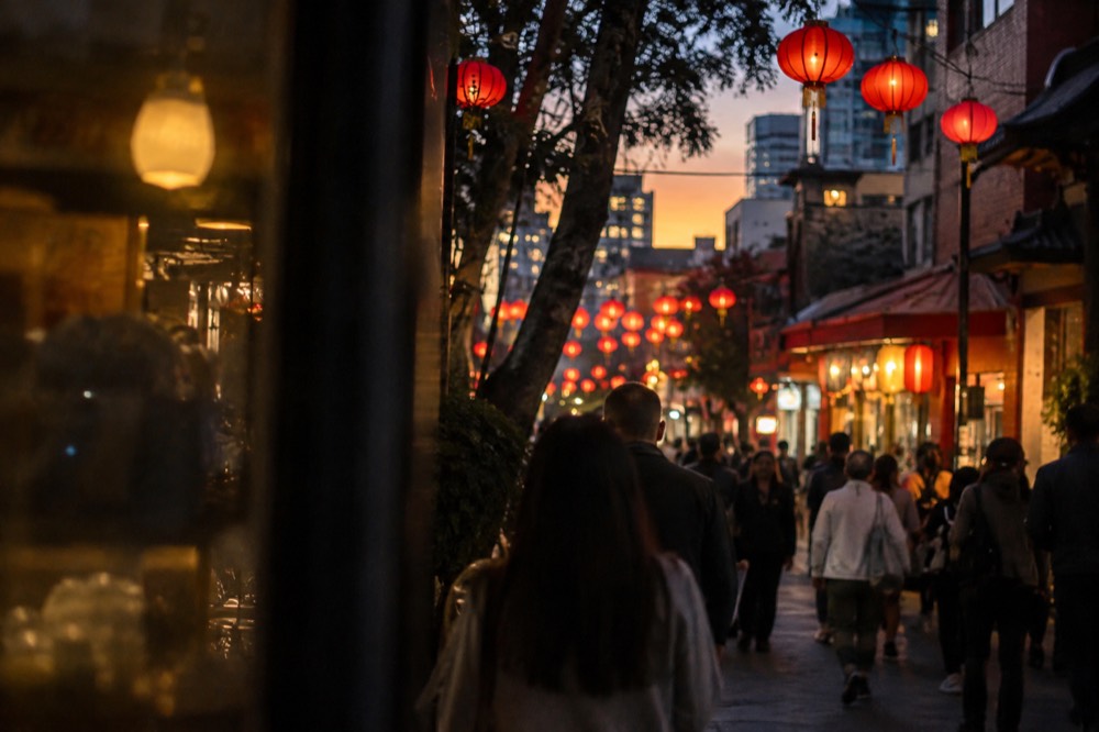 Red lanterns hanging over a busy Chinatown street at dusk