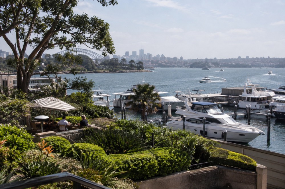 Lush garden terrace overlooking moored yachts on a harbour inlet