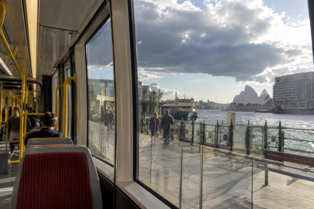 The interior of a modern Sydney light rail tram with wide windows and level boarding doors