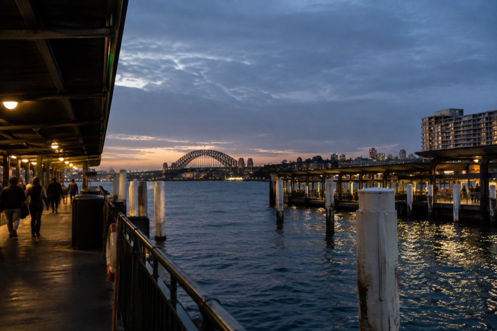 A heritage terrace street in an inner Sydney suburb at dusk with lit windows