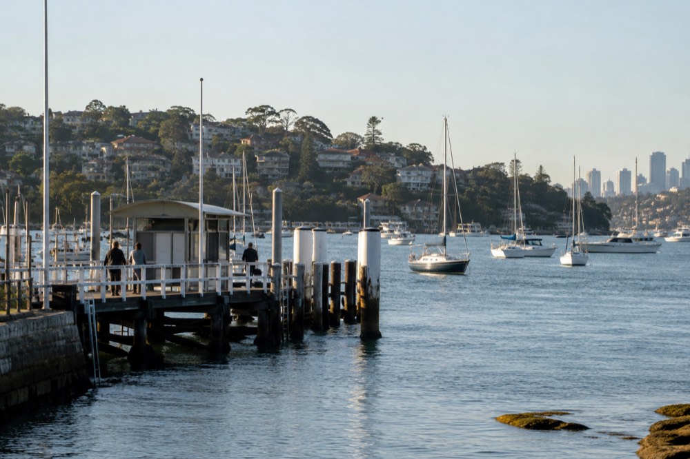 Ferry wharf at Rose Bay with calm water and moored yachts along the shore