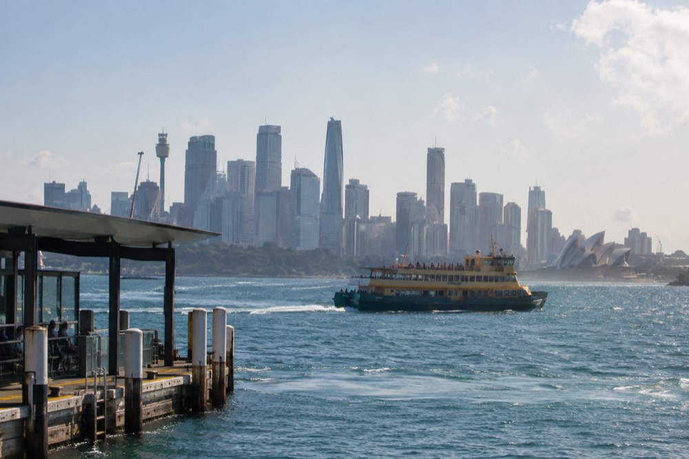 Commuter ferry crossing the harbour in front of the city skyline on a clear afternoon