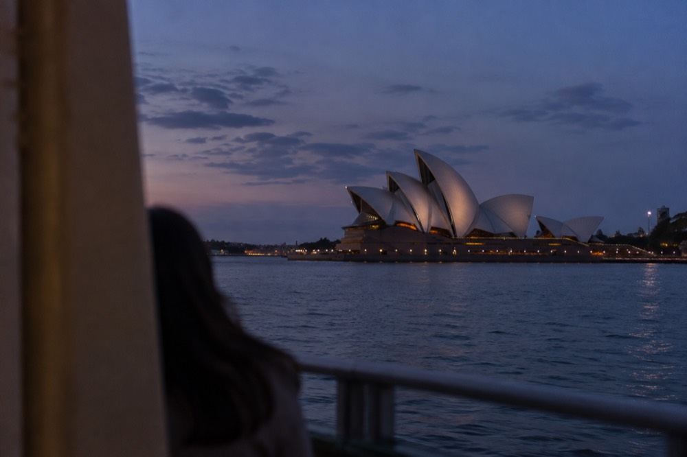 The Sydney Opera House sails glowing under evening lights on Bennelong Point