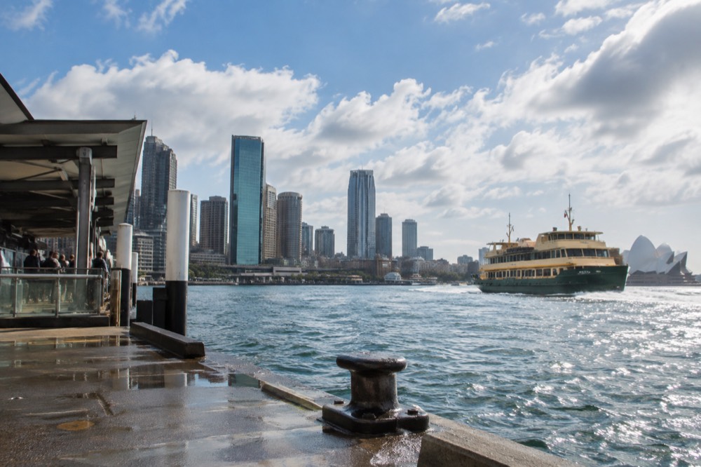 Sunlit harbour water with ferry and skyline