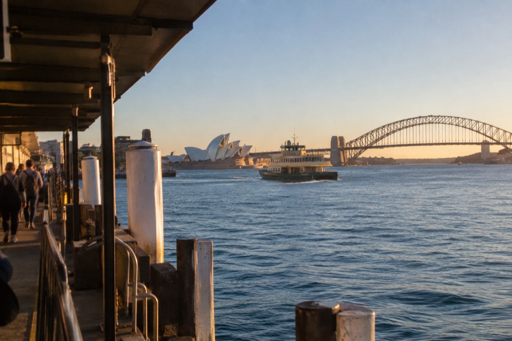 A crisp clear morning over Sydney Harbour with sharp light on the skyline and calm blue water.