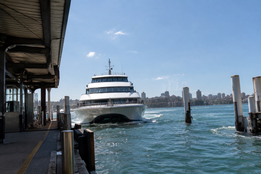 A ferry wharf at Circular Quay with a white ferry approaching the berth