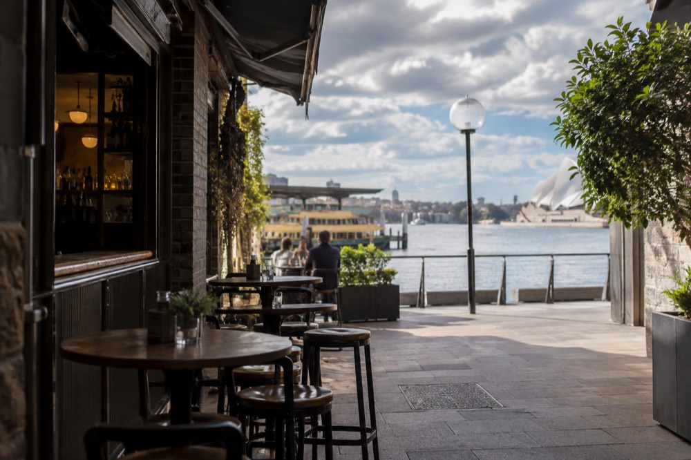 A quiet city laneway with tables set outside a small bar