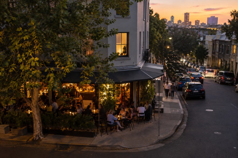 Busy restaurant terrace on a Crown Street corner in Surry Hills in the early evening