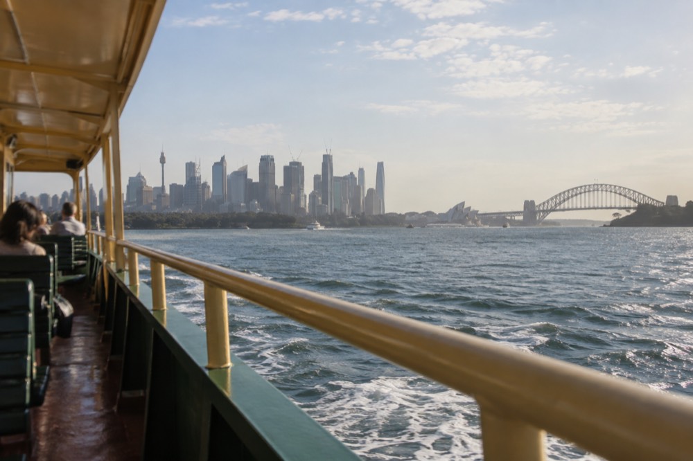 Public ferry crossing Sydney Harbour with the city skyline behind it