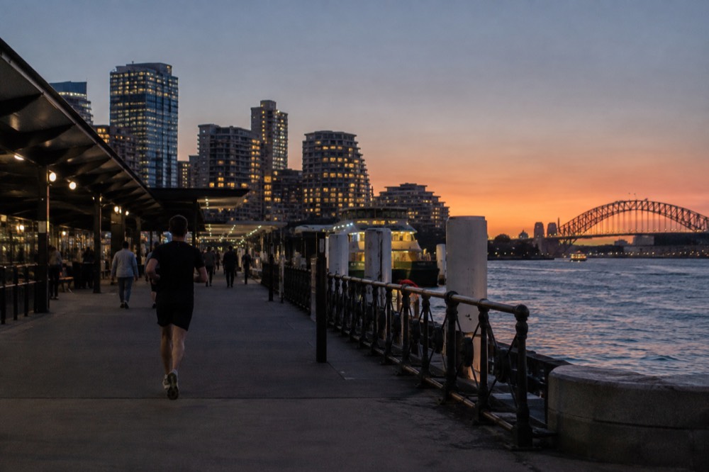 Apartment buildings above the harbour at dusk with city lights