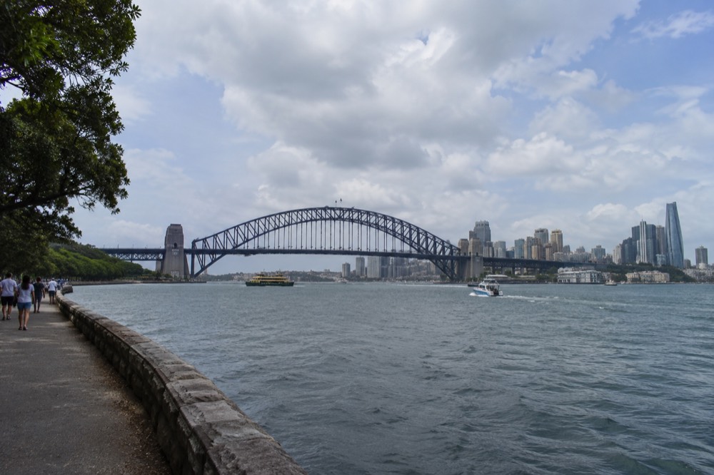 Wide view of the harbour bridge and city towers under scattered summer cloud