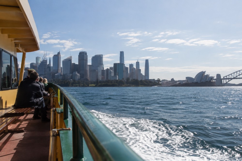 Ferry crossing Sydney Harbour with the city skyline behind it under a pale winter sky