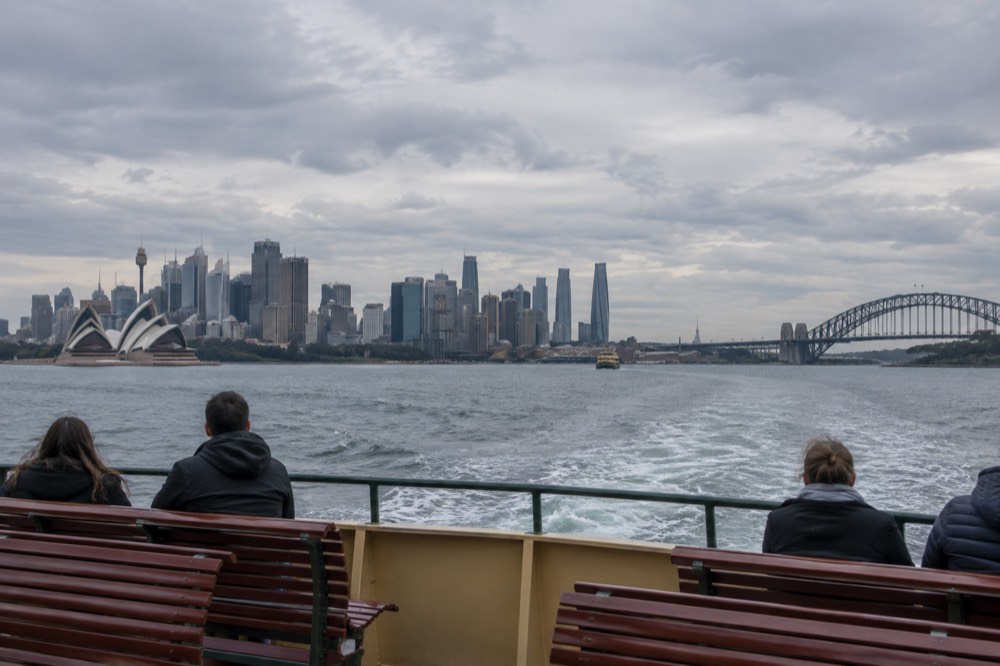 Ferry crossing Sydney Harbour with the city skyline behind it