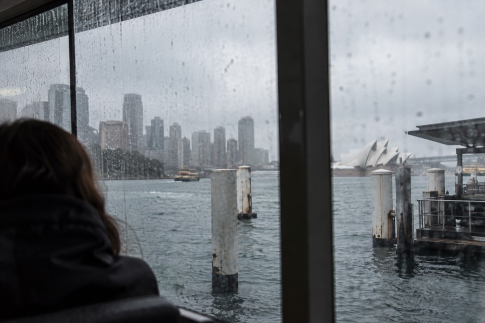 Raindrops on a window with the Sydney skyline blurred in the background