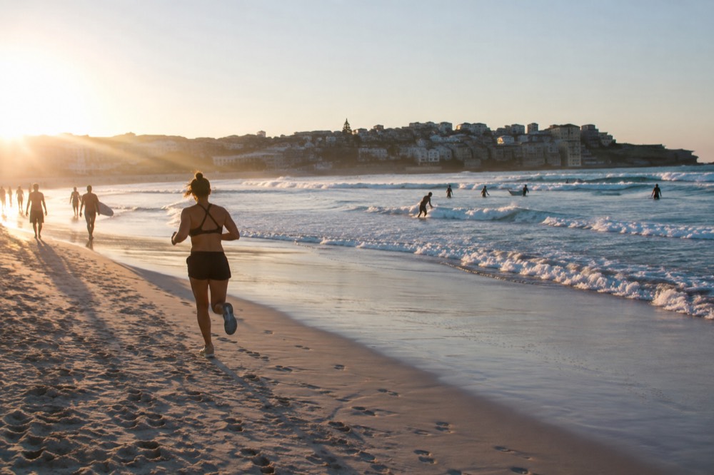 Bondi Beach curving between headlands with surfers near the flags